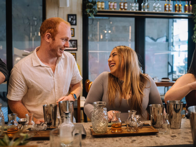 Woman and man smiling at each other at a cocktail class.